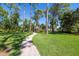 Brick pathway leads to a gazebo nestled in a tropical garden at 761 Soundview Dr, Palm Harbor, FL 34683