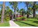 Well-manicured yard featuring a white gazebo framed by tropical landscaping and a brick walkway at 761 Soundview Dr, Palm Harbor, FL 34683
