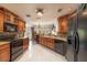 Traditional kitchen with wooden cabinets, granite countertops, and black appliances at 761 Soundview Dr, Palm Harbor, FL 34683
