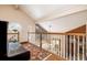 Upper level landing with hardwood floors, piano, and stained glass window at 761 Soundview Dr, Palm Harbor, FL 34683