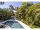 Refreshing pool with patio furniture, nestled amongst tropical foliage at 761 Soundview Dr, Palm Harbor, FL 34683