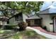 House exterior with a red door and landscaping at 2101 Sunset Point Rd # 1001, Clearwater, FL 33765