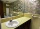Bathroom with yellow tile, sink, and floral wallpaper at 2101 Sunset Point Rd # 1001, Clearwater, FL 33765