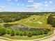 Beautiful aerial view of a golf course, pond and surrounding greenery with blue skies in the background at 4780 Majestic Hills Loop, Brooksville, FL 34601