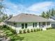 Rear exterior displaying a well-manicured lawn, pristine landscaping, and a covered porch area at 4780 Majestic Hills Loop, Brooksville, FL 34601
