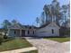 Two-story home with gray brick, white accents, and a paved driveway at 4780 Majestic Hills Loop, Brooksville, FL 34601