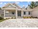 Charming home featuring a brick facade, gray accents, blue shutters, and a spacious front porch at 4780 Majestic Hills Loop, Brooksville, FL 34601