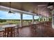 Outdoor porch with ceiling fans, tables, and chairs with a view of the golf course at 4780 Majestic Hills Loop, Brooksville, FL 34601