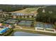 Aerial view featuring multiple tennis and pickleball courts in a lush, green setting with a nearby lake at 4780 Majestic Hills Loop, Brooksville, FL 34601