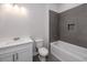 Modern bathroom with white vanity, gray tile, and a bathtub at 4780 Majestic Hills Loop, Brooksville, FL 34601