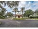 Community clubhouse with palm trees and circular driveway at 6063 Dusk Rose Ln, Brooksville, FL 34601