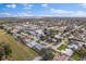 Panoramic aerial view of canal-front homes with pools amidst mature trees under a sunny sky with scattered clouds at 170 98Th N Ave, St Petersburg, FL 33702