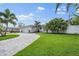 Paver driveway leads up to well maintained home with mature landscaping at 170 98Th N Ave, St Petersburg, FL 33702