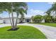 Charming home featuring lush landscaping, a circular driveway, and vibrant green lawn at 170 98Th N Ave, St Petersburg, FL 33702