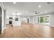 Open floorplan featuring new wood floors, white cabinets, a large island, and a sliding glass door at 170 98Th N Ave, St Petersburg, FL 33702