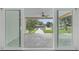 A covered patio and canal dock are viewed through sliding glass doors at 170 98Th N Ave, St Petersburg, FL 33702