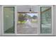 A covered patio and the canal with a dock are viewed through sliding glass doors at 170 98Th N Ave, St Petersburg, FL 33702
