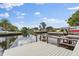 Waterfront view showcasing a wooden dock, boat lift, and tranquil canal at 170 98Th N Ave, St Petersburg, FL 33702