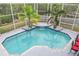 Aerial view of a screened-in pool area showcasing a serene waterfall feature and landscaping at 2093 N Pointe Alexis Dr, Tarpon Springs, FL 34689