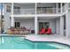 Backyard pool area featuring an outdoor bar and a row of chairs perfect for entertaining at 2093 N Pointe Alexis Dr, Tarpon Springs, FL 34689