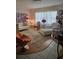 Bright living room displays a colorful art piece, white sofa, modern seating, and stylish furnishings on wood floors at 6015 19Th N St # 308, St Petersburg, FL 33714