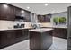 Modern kitchen with dark cabinets, granite island, and stainless steel appliances at 6070 Denver Ne St, St Petersburg, FL 33703