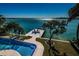 Expansive backyard featuring a private dock, swimming pool, lush landscaping, and stunning waterfront views at 516 Belle Isle Ave, Belleair Beach, FL 33786