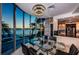 Dining room with a beautiful sunset view, a glass table with seating for six, and access to a modern kitchen at 516 Belle Isle Ave, Belleair Beach, FL 33786