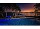 Waterfront property with a private dock and an infinity pool overlooking the bay at sunset at 516 Belle Isle Ave, Belleair Beach, FL 33786