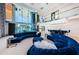 Open-concept living room with water view, wet bar, modern furniture, and grand staircase at 516 Belle Isle Ave, Belleair Beach, FL 33786