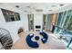Spacious living room with a large blue sectional couch, fireplace, and views of the pool outside at 516 Belle Isle Ave, Belleair Beach, FL 33786