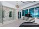 Spacious main bedroom boasting water views, marble tiled shower, and custom lighting fixtures at 516 Belle Isle Ave, Belleair Beach, FL 33786