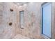 Luxurious tiled shower featuring elegant fixtures and integrated window details at 516 Belle Isle Ave, Belleair Beach, FL 33786