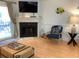 Living room with corner fireplace, TV, and blue accent chair at 19930 Gulf Blvd # 1A, Indian Shores, FL 33785