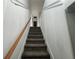 Carpeted staircase with wood railing leading to upper level at 19930 Gulf Blvd # 1A, Indian Shores, FL 33785