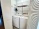 Bright laundry room with washer, dryer, and shelving at 19930 Gulf Blvd # 1A, Indian Shores, FL 33785