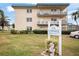 Inviting condominium complex with lush landscaping and a welcoming sign, close to parking at 5750 80Th N St # B208, St Petersburg, FL 33709