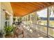 Long wooden porch with a wooden ceiling, white railings, and scenic views at 3136 Neff Lake Rd, Brooksville, FL 34602