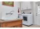 Bright laundry room features updated washer and dryer, a vintage sink, and ample cabinetry at 3136 Neff Lake Rd, Brooksville, FL 34602
