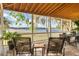 Relaxing back porch overlooking a lake with wooden chairs and table at 3136 Neff Lake Rd, Brooksville, FL 34602