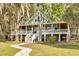 Elevated home with a wraparound porch and a stone pathway at 3136 Neff Lake Rd, Brooksville, FL 34602