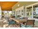 Relaxing covered porch with wooden dining table and chairs, overlooking a pond at 3136 Neff Lake Rd, Brooksville, FL 34602