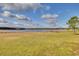 Scenic view of a lake with grassy area and trees under a partly cloudy sky at 3136 Neff Lake Rd, Brooksville, FL 34602