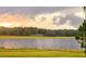 Stunning sunset over a calm lake with grassy shoreline and distant trees at 3136 Neff Lake Rd, Brooksville, FL 34602