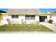Front view of charming yellow house with well-manicured lawn at 7057 Versailles N # 15, Pinellas Park, FL 33781