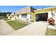 House exterior featuring a yellow facade and attached garage at 7057 Versailles N # 15, Pinellas Park, FL 33781