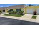 Bright yellow house with a double-car garage and landscaping at 7057 Versailles N # 15, Pinellas Park, FL 33781