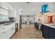 Open concept kitchen boasts white cabinets, blue tile backsplash, and stainless steel appliances at 570 Casler Ave, Clearwater, FL 33755