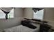 Bedroom with two windows, a bed, and dark wood furniture at 1153 Tamarac Dr, Holiday, FL 34690