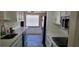 Bright kitchen with white cabinets, stainless steel appliances, and quartz countertops at 1153 Tamarac Dr, Holiday, FL 34690